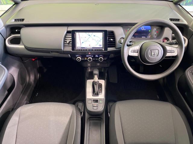 フィット ｅ：ＨＥＶベーシック　禁煙車　純正９型ナビ　バックカメラ　衝突被害軽減システム　レーダークルーズ　コーナーセンサー　スマートキー　ＬＥＤヘッド　ビルトインＥＴＣ　オートハイビーム　車線逸脱警報　オートライト　オートエアコン（2枚目）