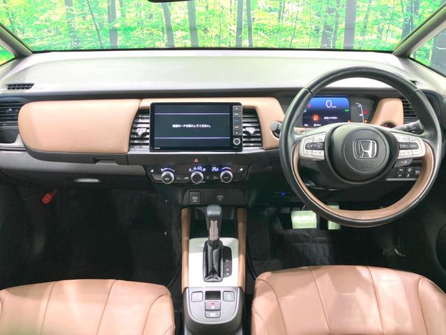 フィット ｅ：ＨＥＶリュクス　禁煙車　純正ＳＤナビ　バックカメラ　衝突被害軽減システム　レーダークルーズ　ハーフレザーシート　ドラレコ　コーナーセンサー　スマートキー　ＬＥＤヘッド　ビルトインＥＴＣ　オートライト　オートエアコン（2枚目）