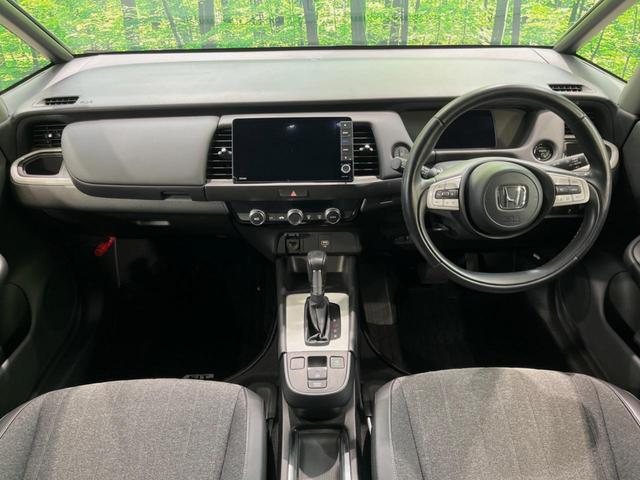 フィット ｅ：ＨＥＶホーム　純正９型ナビ　バックカメラ　衝突被害軽減システム　レーダークルーズ　ハーフレザーシート　ドラレコ　コーナーセンサー　スマートキー　ＬＥＤヘッド　ビルトインＥＴＣ　オートハイビーム　車線逸脱警報（2枚目）