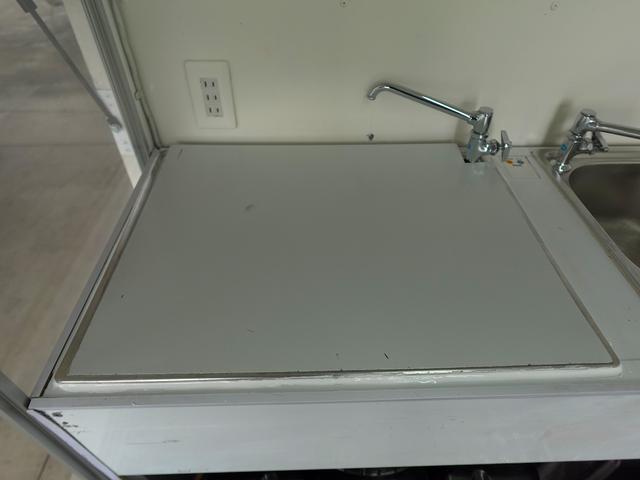 キャリイトラック 移動販売車 キッチンカー ケータリングカー フードトラック 3槽シンク 100L給排水タンク 冷凍冷蔵コールドテーブル 換気扇 照明 扉付きバンク収納 外部電源 跳上扉 アクリル窓 カウンター(15枚目)