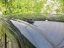 フロントガラスからルーフへ続くなだらかなラインが、車体をすっきりと見せています。中央付近にはアンテナが備わり、濃色のボディと周囲の景色が映り込む表情も印象的です。