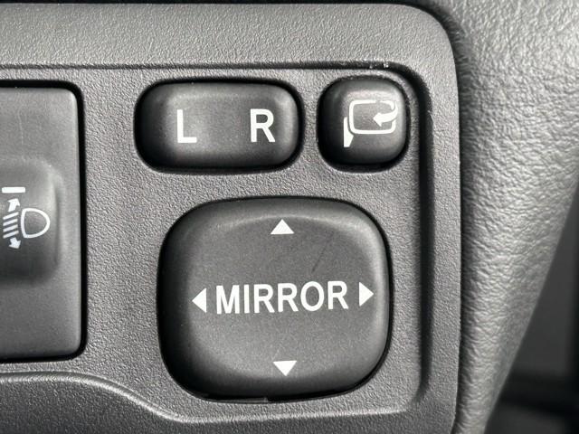 電動格納ミラーの操作スイッチですね。　駐車時にミラーを動かそうと外に出る必要も無く、悪天候の時でも運転席に居ながらミラーの操作できますよ。　一度使うと手放せない装備ですよね。