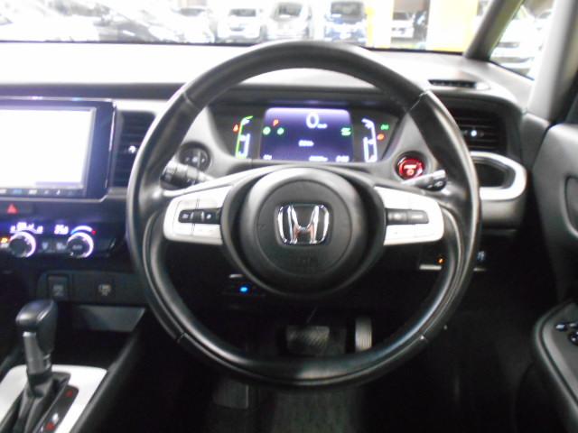 フィット ｅ：ＨＥＶホーム　８型ベーシックインターＮ　アームレストＣ　前後ドライブＲ　コンフォートビューＰ　純正１６インチアルミＷ　パーキングセンサーＳ　本革巻ステアリングＷ＋セレクトＬ　照明付スマートフォンＴ　車両接近通報装置（16枚目）