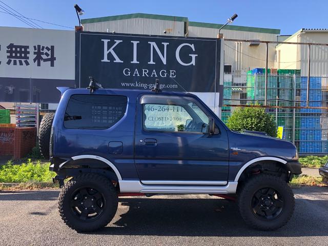 ジムニー ワイルドウインド　８０周年記念車　４ＷＤ　モーターファーム３インチリフトアップ　社外ラテラル　社外マフラ－　社外１６インチアルミ　マッドタイヤ　ロングブレーキホース　ＬＥＤヘッド　ＬＥＤテール　背面タイヤ　ＥＴＣ（9枚目）