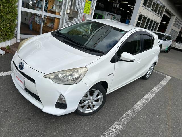 アクア Ｇ　ナビＴＶバックカメラＥＴＣ車載器スマートキー２本Ｐスタートイモビライザー禁煙車スペアタイヤ付純正アルミ革巻きハンドル衝突安全ボディーリヤスポイラーハイブリッド車ホワイトパール電格ミラーオートエアコン付（2枚目）