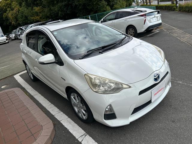 アクア Ｇ　ナビＴＶバックカメラＥＴＣ車載器スマートキー２本Ｐスタートイモビライザー禁煙車スペアタイヤ付純正アルミ革巻きハンドル衝突安全ボディーリヤスポイラーハイブリッド車ホワイトパール電格ミラーオートエアコン付（6枚目）