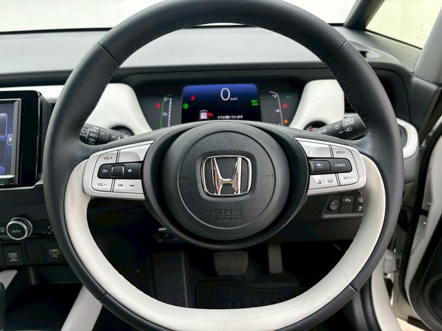 フィット ｅ：ＨＥＶホーム　ＡＣＣフルセグナビＬＥＤヘッドＲカメラＥＴＣサイドカーテンエアバッグ電制ＰオートブレーキホールドＢＴドラレコＵＳＢパーキングセンサ純正アルミ本革巻きステアリングＣＤＤＶＤ再生スマキー（19枚目）