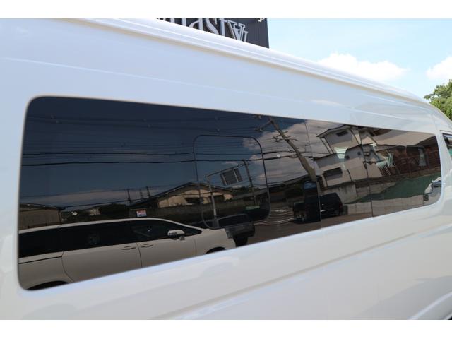 ハイエースコミューター スーパーロングＧＬ　３ナンバー乗用車登録１０人３列目対面ラウンジベッド家具テーブルフローリング天井ダウンライトバケットシートカバーセンターコンソールアルパインＢＩＧＸ１１ナビ後席１２．８ｉｎモニター２ピース１８ｉｎアルミ（16枚目）