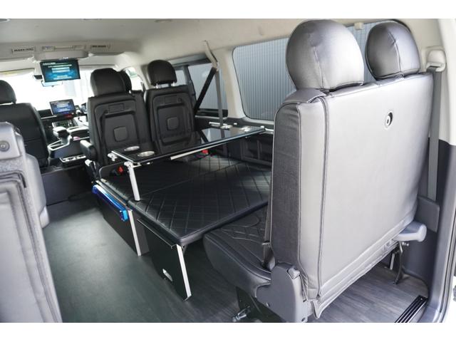 ハイエースワゴン 　登録済未使用車３列目対面ラウンジベッド家具フローリングテーブルＩＦ－ＷＢ８フルフラットベットラウンジ展開カロッツエリアナビ後席モニターミラーリングウッドインテリアバケットシートカバーセンターコンソール（32枚目）
