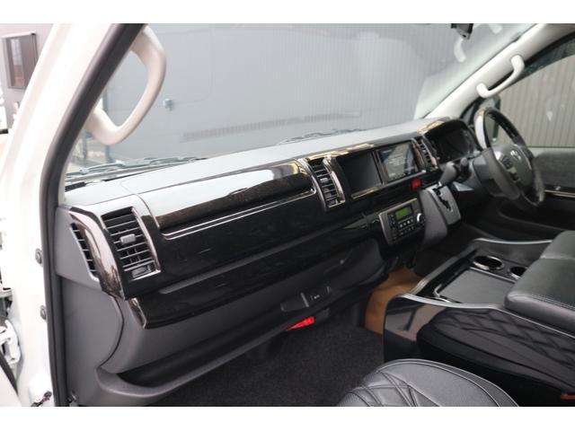 ハイエースワゴン 　登録済未使用車３列目対面ラウンジベッド家具フローリングテーブルＩＦ－ＷＢ８フルフラットベットラウンジ展開カロッツエリアナビ後席モニターミラーリングウッドインテリアバケットシートカバーセンターコンソール（50枚目）