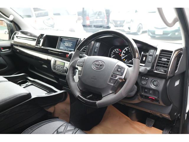 ハイエースワゴン 　登録済未使用車３列目対面ラウンジベッド家具フローリングテーブルＩＦ－ＷＢ８フルフラットベットラウンジ展開カロッツエリアナビ後席モニターミラーリングウッドインテリアバケットシートカバーセンターコンソール（56枚目）