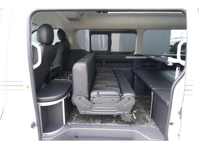 ハイエースワゴン ＧＬ　登録済み未使用車２列目３名Ｉ－ｓｅａｔＲＥＶＯシート対面ラウンジベッド家具ＩＦ－ＷＲ９フローリングテーブル天井間接照明フルフラットベッド対面ラウンジ地ナビ後席モニター天井スピーカーセンターコンソール（32枚目）