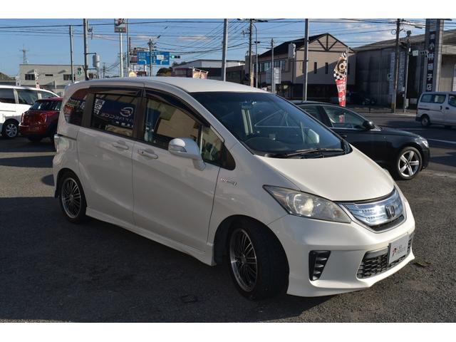 フリードハイブリッド ジャストセレクション　スマートキー　純正ＨＤＤナビ　ベンチシート　オートエアコン　バックカメラ　左側パワースライドドア　社外ホイール　７人乗りフリップダウンモニター　ＥＴＣ（3枚目）