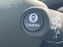 丸いボタンの中央には車両を示す図柄と「ＣＡＭＥＲＡ」の文字が配置されています。近くのレバーにも表示があり、手元の各表記を確認しやすいまとまりです。