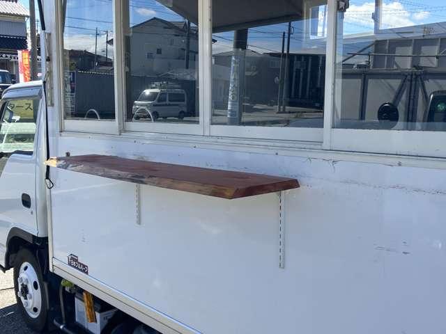 エルフトラック 　ＴＲＧ－ＮＨＳ８５ＡＮ　キッチンカー　オーニング　コールドテーブル業務用冷蔵庫　冷蔵冷凍庫　外部電源・コード　２槽シンク　給排水　換気扇　コンセント×５　カウンター　作業台×３　スポットライト　ＬＥＤ（5枚目）