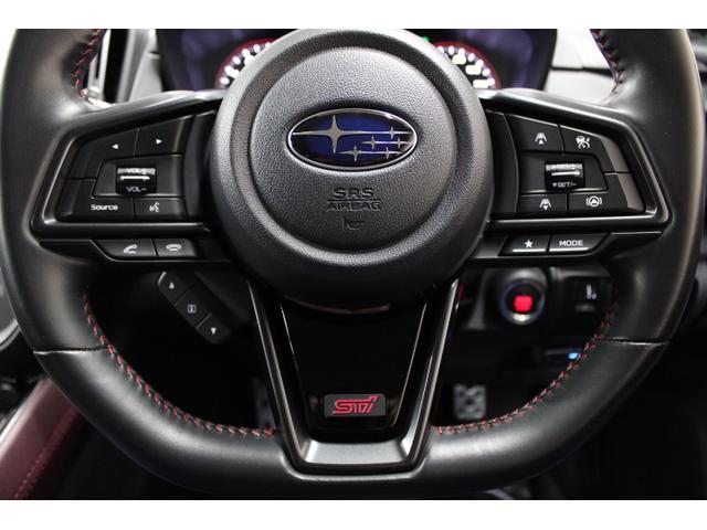 レッドステッチ、ピアノブラック調加飾パネルの本革巻ステアリングホイール。