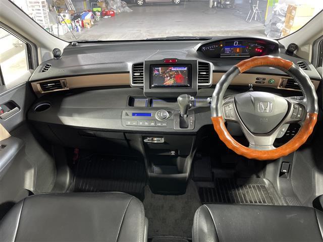 フリードハイブリッド ジャストセレクション　禁煙車　両側電動パワースライドドア　社外サブウーファー　社外ナビ　（ＣＤ／Ｂｌｕｅｔｏｏｔｈ／フルセグＴＶ）　バックカメラ　革調シートカバー　社外ツイーター　純正ラバーマット　オートライト　ＥＴＣ（2枚目）