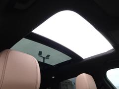 【パノラミックルーフ】車内に気持ちいい自然光が差し込み、頭上に広がる風景をお楽しみいただけます。快適な車内温度を維持し日差しから乗員とインテリアを守るダークカラーのガラス。電動ブラインド付き！ 4