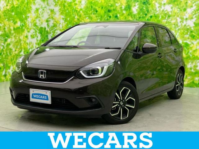 フィット ｅＨＥＶホーム　新品タイヤ／純正　８インチ　ＳＤナビ／ホンダセンシング／車線逸脱防止支援システム／シート　ハーフレザー／ヘッドランプ　ＬＥＤ／Ｂｌｕｅｔｏｏｔｈ接続／ＥＴＣ／ＥＢＤ付ＡＢＳ／横滑り防止装置　ＤＶＤ再生（1枚目）