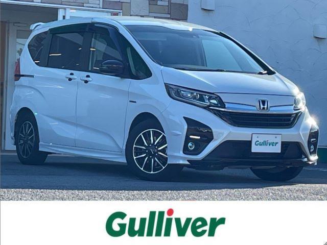 フリードハイブリッド ハイブリッド・モデューロＸ　ホンダセンシング　純正９インチナビ／バックカメラ／無限ドアプロテクター／両側パワースライドドア／追従式クルコン／ＬＥＤヘッドライト／ＬＥＤフォグライト／オートライト／ＥＴＣ／純正１５ＡＷ／ドアバイザー／電動格納ミラー（1枚目）