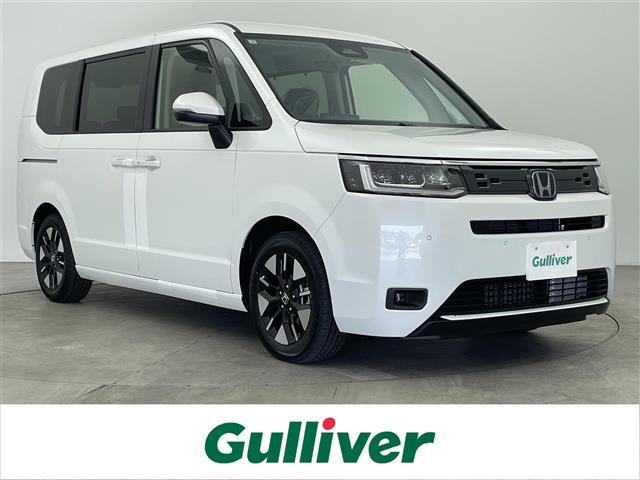 ステップワゴン(ホンダ) ｅ：ＨＥＶエアー　ＥＸ　純正ナビ　Ｂカメラ　ホンダセンシング　パワーバックドア　衝突軽減ブレーキ　先行発進お知らせ機能　ＢＳＭ　電子パーキング　オートホールド　純正フリップダウンモニター　シートヒーター　オットマン 中古車画像