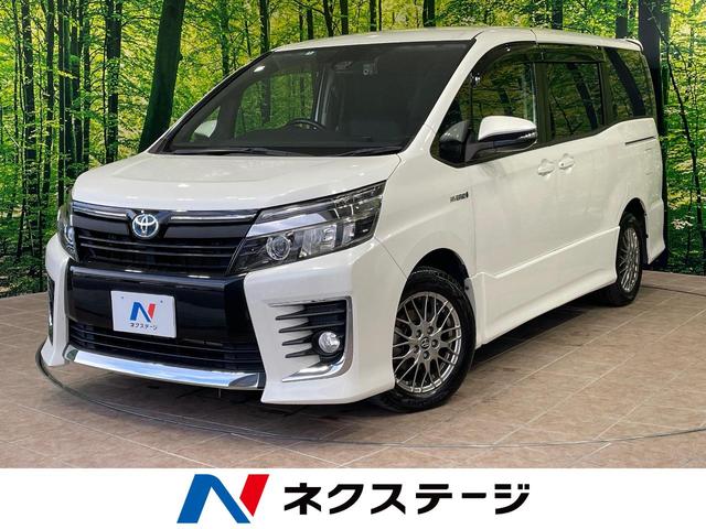 ヴォクシー(トヨタ) ハイブリッドＺＳ　１年保証付　両側電動ドア　後席モニター　バックカメラ　衝突被害軽減システム　禁煙車　ドラレコ　スマートキー　ＬＥＤヘッド　ＥＴＣ　純正１６インチアルミ　オートハイビーム　オートライト　デュアルエアコン 中古車画像