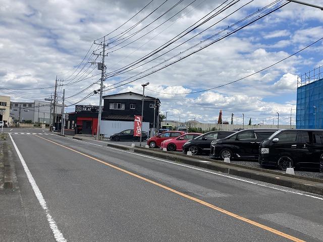 交差点手前に中古車展示場と駐車場がございます。